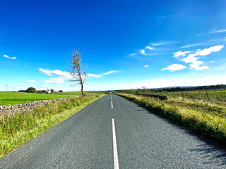 Looking along, Redlish Road, with dry stone walls, and a vivid blue sky in, Thornthwaite, Harrogate, UK
