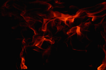 Fototapeta na wymiar Abstract fire flame in fireplace, texture for background. Beautiful bright orange flames flicker in the darkness of the night.