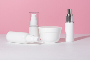 Set of white cosmetic bottles and jars with hard shadows. Beauty salon concept.