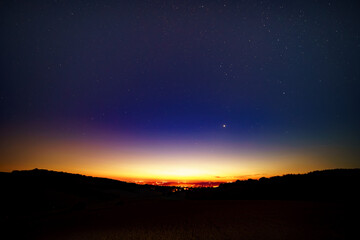 Night landscape with light from the city on the horizon