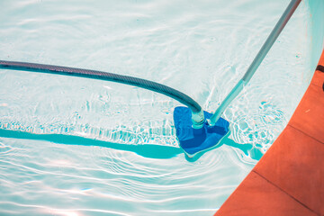 Swimming pool cleaning tools in the bottom of the pool. Clear water in the pool.