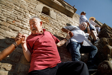 gruppo di anziani signori sia iuta prendendosi la mano , nello scale i gradini di un antico edificio