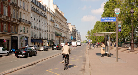 Naklejka premium According to the Quai Voltaire moving pedestrians, cyclists and cars