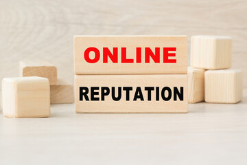 the word ONLINE REPUTATION is written on a wooden cubes structure. Cube on a bright background. Can be used for business, marketing, financial concept. Selective focus.