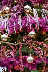 Decorative baubles, ribbons and garlands hang from an artificial tree, all in purple and violet tones. Heralds the spirit and joy of Christmas.