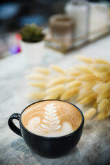 Cup of cappuccino with a pattern on a wooden table.