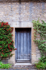 Fototapeta na wymiar Step back in time and visit Castle Combs, quaint village with well preserved masonry houses dated back to 13 century. Very old weathered door in house in a picturesque medieval village in England. UK.