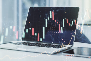Abstract creative financial graph with world map on modern laptop background, forex and investment concept. Multiexposure