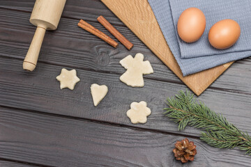 Eggs on gray napkin. Cookie shapes cut from dough. Spruce twigs and pine cone