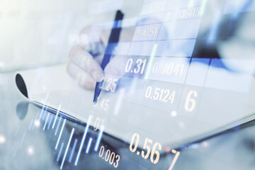 Multi exposure of abstract financial graph with hand writing in notebook on background, financial and trading concept