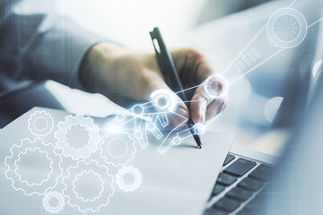 Double exposure of robotics technology hologram and hand writing in notebook on background with laptop. Research and development software concept