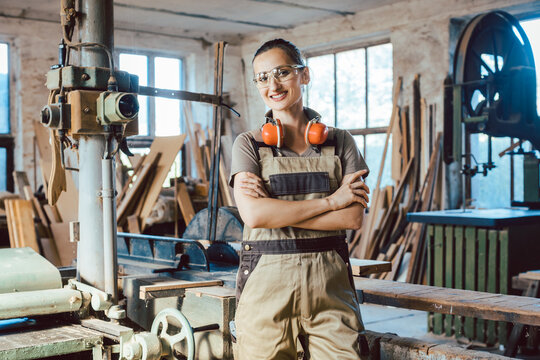 Beautiful woman carpenter in her woodwork workshop