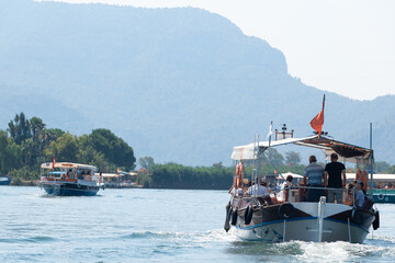Boats with tourists floating on the river against the background of mountains