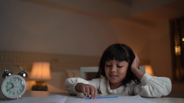 Student little girl hand raised up to celebrate after done the homework at night.