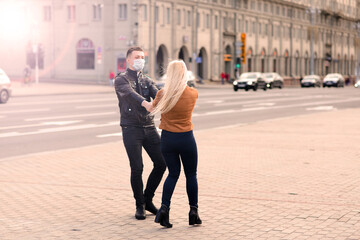 Obraz premium Young couple in masks on city street.