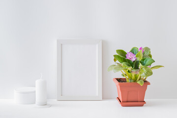  Mockup with a white frame, flowers in a pot on a light background