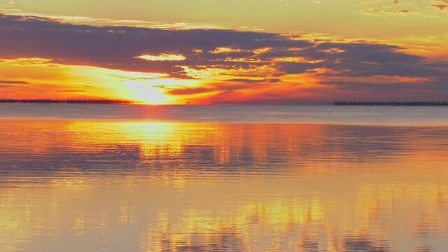 Dramatic vivid sunset over a Florida ocean bay with calm reflection