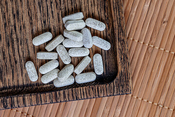 close-up of ester-c tablets on a wooden background.  biologically active supplements topview photo.