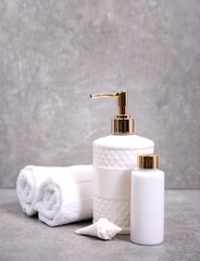 Towels and cosmetic bottles on grey stone background.Shower set,spa products,body care and hygiene.