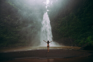Beautiful girl having fun at the waterfalls in Bali. Concept about wanderlust traveling and...