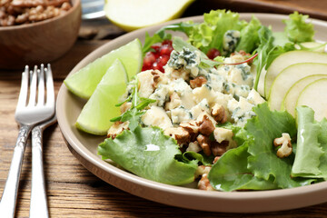 Fresh salad with pear served on wooden table