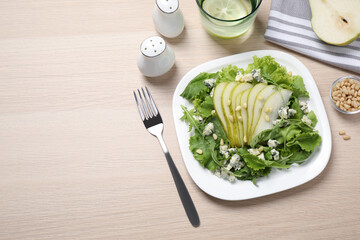 Fresh salad with pear served on wooden table, flat lay. Space for text