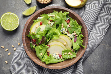 Fresh salad with pear on grey table, flat lay