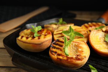 Delicious grilled peaches with mint on table, closeup