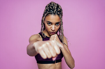 Beautiful girl doing exercises and sport. Posing on a pink colored background