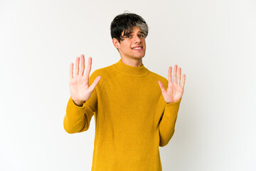 Young skinny hispanic man rejecting someone showing a gesture of disgust.