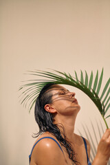 Portrait of girl in swimsuit with palm branch