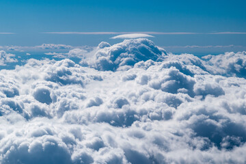 Blue sky full of white clouds in a photo taken in an airplane