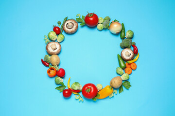 Frame of different fresh vegetables on light blue background, flat lay. Space for text