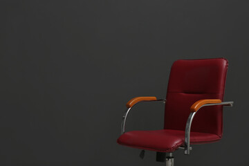 Comfortable office chair on black background. Space for text