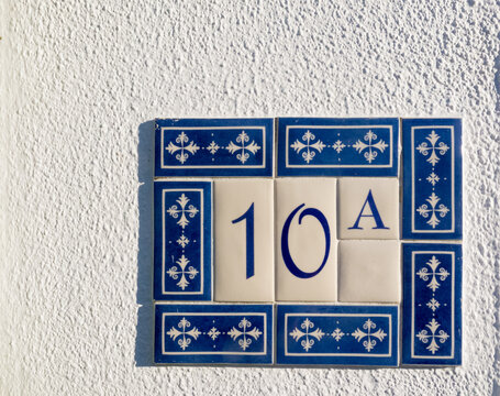 number 10 on a wall surrounded by ceramic decorative tiles as a house number
