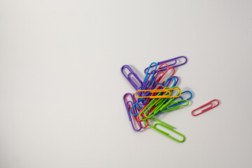 Office colored paper clips on a white background