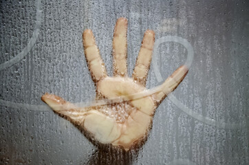 Hand on wet window