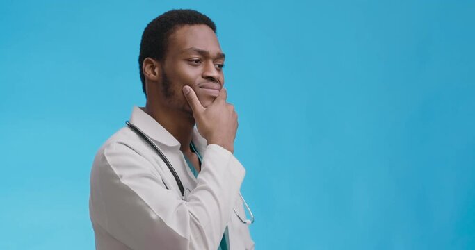 Studio portrait of thoughtful african american doctor thinking over hard medical case, blue background