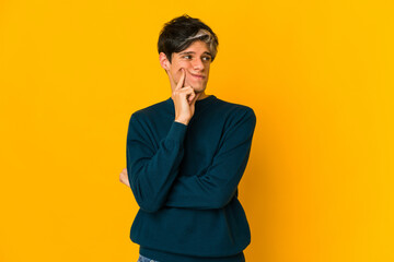 Young skinny hispanic man contemplating, planning a strategy, thinking about the way of a business.