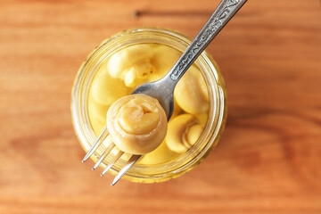 Canned champignons in the bank, top view. Fermented products.