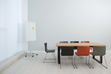 Conference room interior with wooden table and flipchart