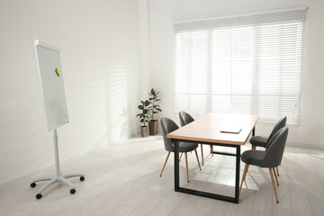 Conference room interior with wooden table and flipchart