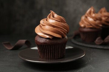 Delicious fresh chocolate cupcake on black slate table, closeup