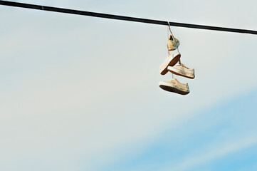 Two pairs of shoes hanging from powerlines