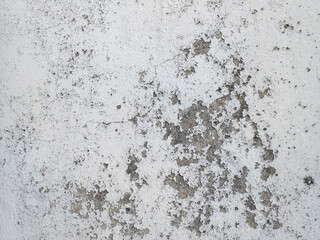 Uncorked white cement wall background. Cracked concrete wall lined with white cement as a background. Cracked concrete texture closeup background. Masonry and construction concept.