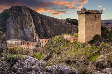 Fototapeta premium Landscape with the tower of Alhama de Aragon and the mountains that surround it, view of the keep of the only rest that remains standing of what was one castle, Spain