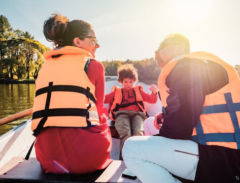 Cheerful Father, Little Son And Teenage Daughter Sitting On Boat In Life Vests On Summer Day. Family Walks At The Boat Station, Selective Focus