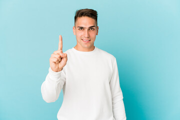 Young caucasian handsome man isolated showing number one with finger.