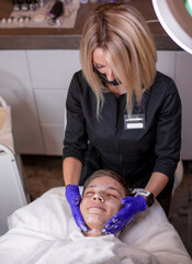 A young beautiful teenager with dark hair, a specialist woman with light hair performs a procedure...