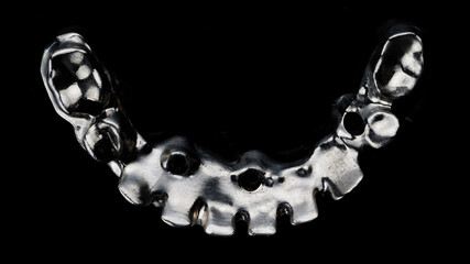 titanium dental bar for making a prosthesis, taken in a black photo, top view